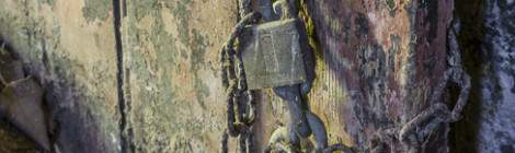 ...Ancienne chaine et cadenas sur une porte en bois....