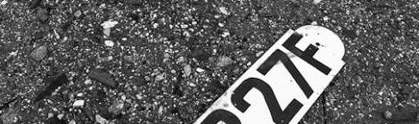 ...De cette p&eacute;niche d&eacute;truite il ne reste que deux plaques d&rsquo;immatriculation tomb&eacute;es au sol, photo en noir et blanc....