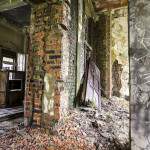 Bâtiment en friche avec moisissure sur les murs et porte défoncée