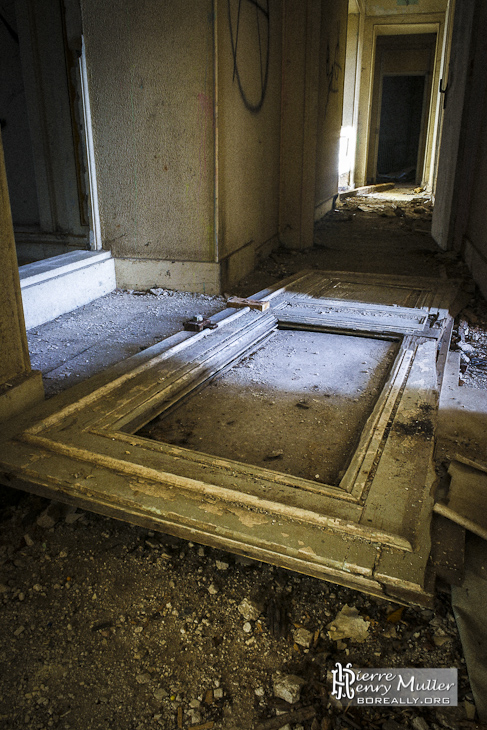 Couloir et porte au sol dans le château abandonné de Bonnelles