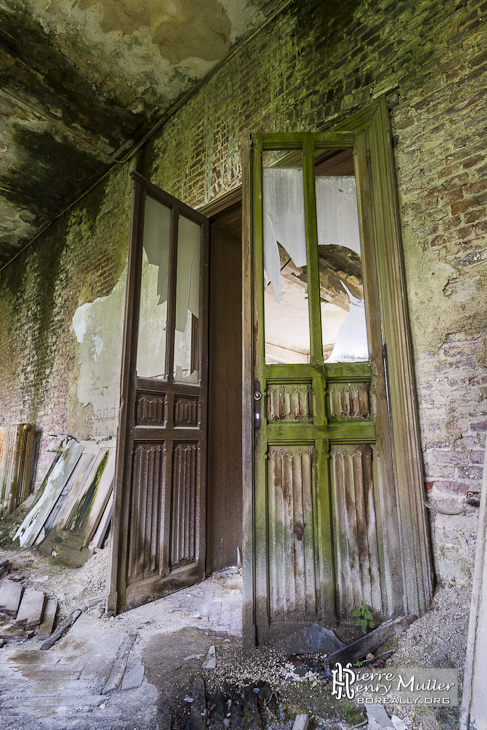 Double porte vermoulue avec moisissure au château de Mesen