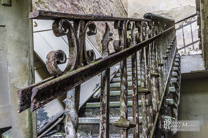 Rampe d'escalier en fer forgé rouillé au château abandonné de Mesen