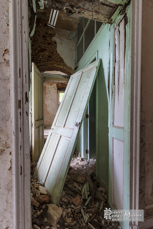 Couloirs du château Miranda avec porte dégondée