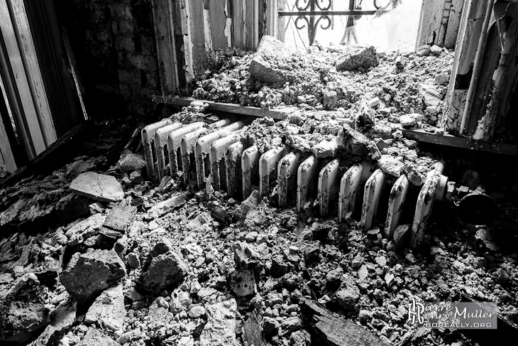 Effondrement sur un radiateur en fonte près d'une fenêtre en noir et blanc