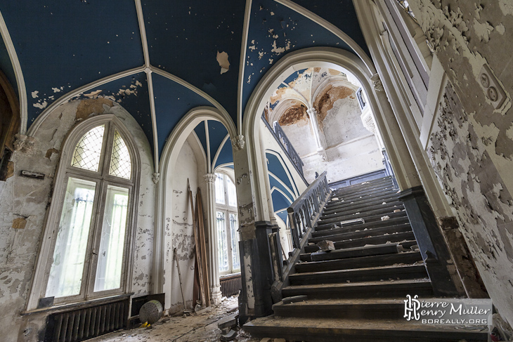 Escalier principal du château Noisy avec plafond bleu en croisée d'ogive