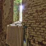 Pièce délabrée avec radiateur en fonte et fenêtre au château Noisy en HDR