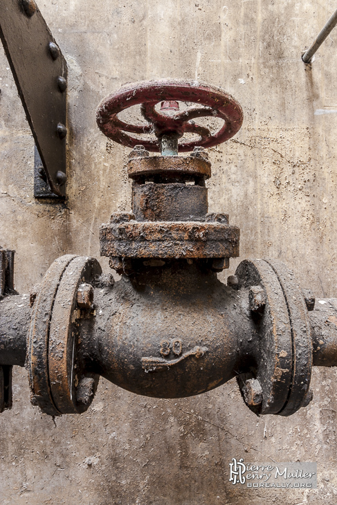 Vanne hydraulique rouillée dans une friche industrielle