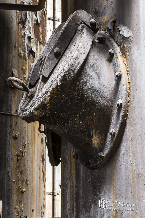 Trappe dans une colonne rouillée