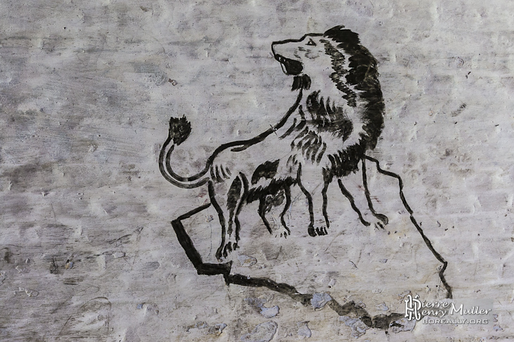 Dessin d'un lion sur un rocher sur les murs du fort de la Chartreuse