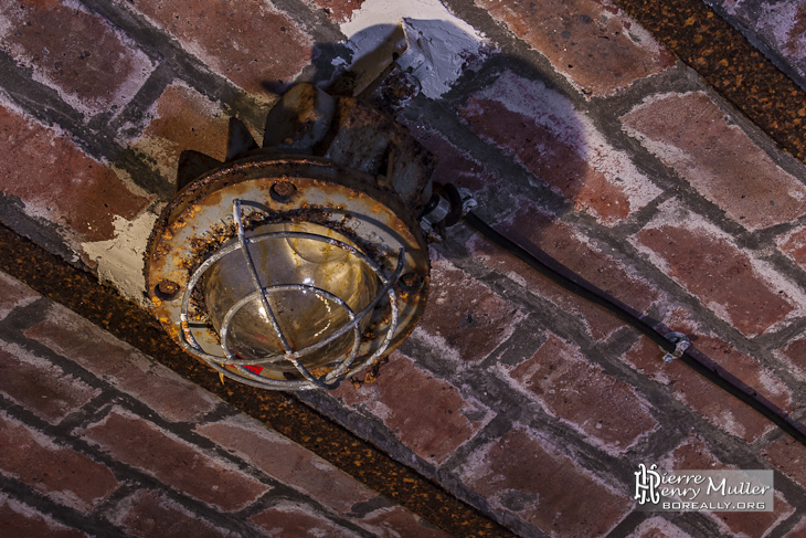 Lampe électrique rouillée au plafond du souterrain du Fort du Haut Buc