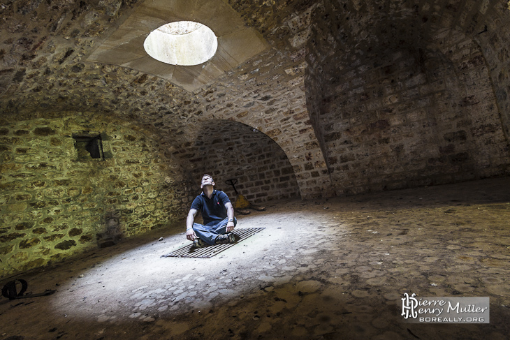 Personne sous un puits de lumière dans un abri sous traverse du Fort du Haut Buc