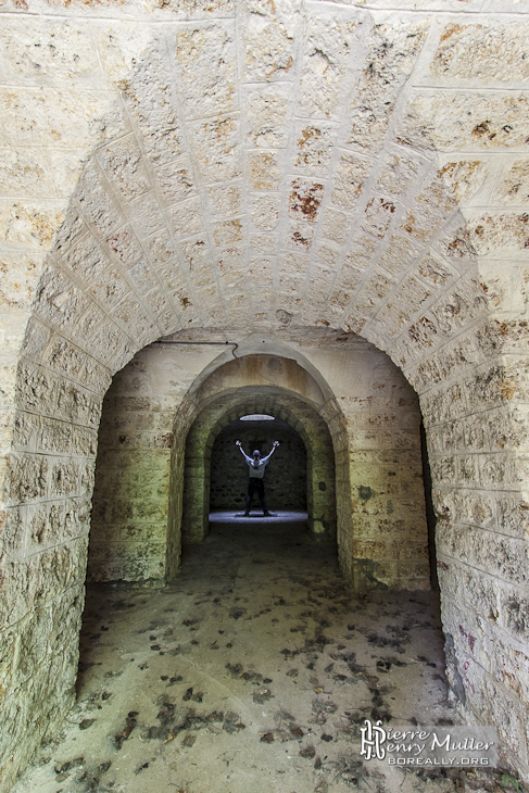 Piliers d'un abri sous traverse avec personne sous puits de lumière au Fort du Haut Buc