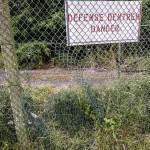 Trou dans l'enceinte grillagée avec panneau défense d'entrer danger