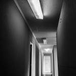 Photo noir et blanc d'un couloir éclairée aux néons de l'imprimerie abandonnée