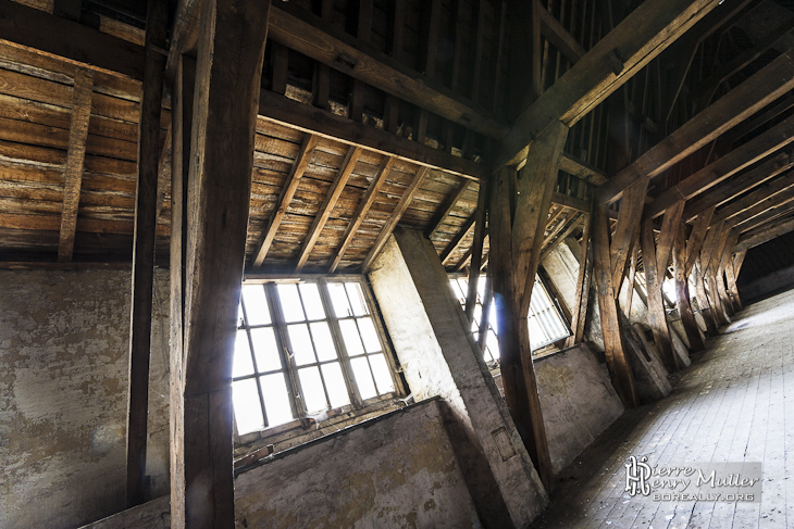 Fenêtres sous les toits avec la charpente en bois du monastère abandonné