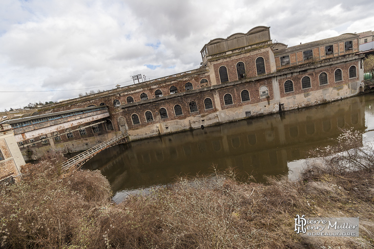 Bâtiment de la papeterie au bord de la rivière Essonnes avec ses passerelles