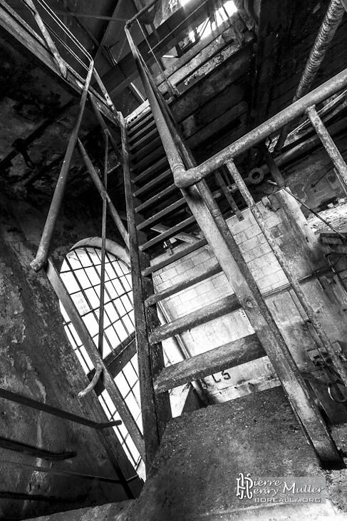 Escalier métallique à la papeterie Darblay en noir et blanc