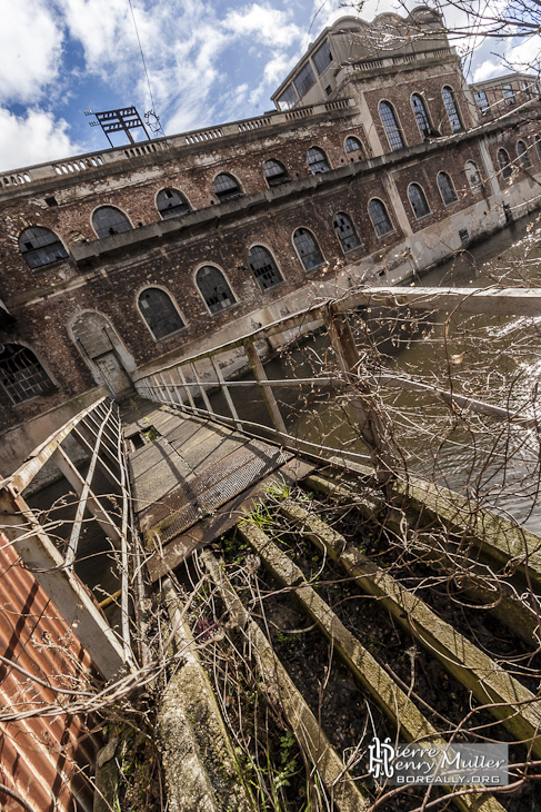 Passerelle inter bâtiments de la papeterie au dessus de la rivière en portrait