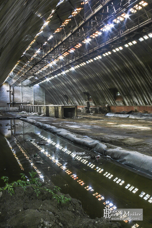 Hangar de stockage aux multiples fenêtres et son reflet à l'usine SAFEA