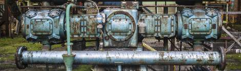 ...La couleur bleue de cette machine hydraulique qui s’écaille laissant apparaitre de la rouille renvoie une forte présence dans ce hangar plutôt rouge....