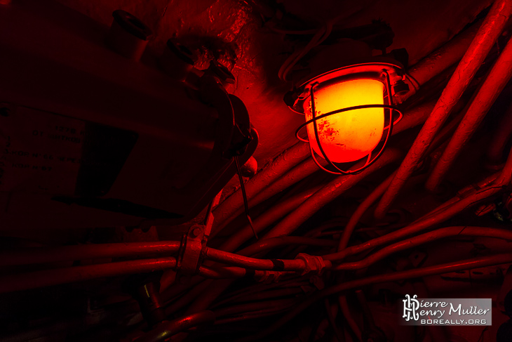 Eclairage rouge dans le sous-marin russe au milieu des câbles