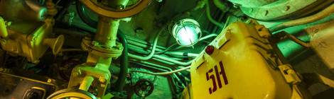 ...Lampe verte au milieu des c&acirc;bles et vannes du sous-marin russe Black Widow....