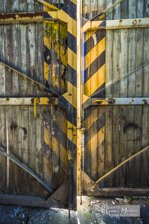 Porte en bois peinte en jaune et noir du dépôt de trains