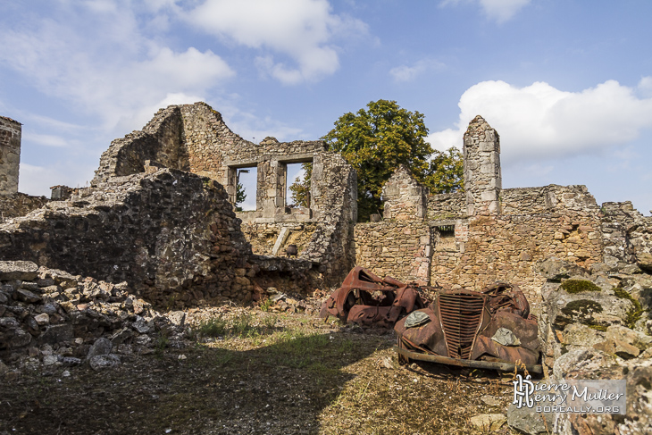 Ruine de maisons avec voitures à Oradour