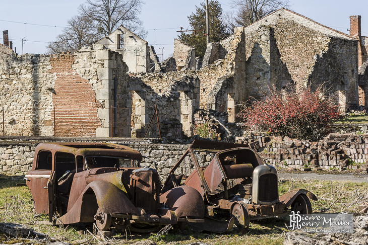 Voitures et village en ruine à Oradour sur Glane