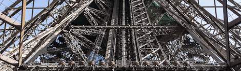 ...La structure métallique typique de la Tour Eiffel avec ses rivets depuis le premier étage. On distingue un tronçon de l’ancien escalier en colimaçon qui permettait d’accéder aux différents étages avant l’apparition des ascenseurs....