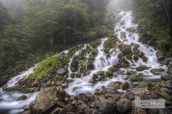 Cascade de montagne dans la brume en pause longue