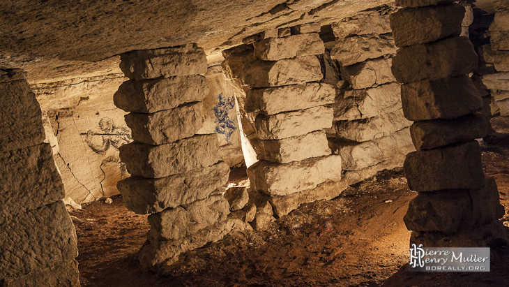 Dessins sur les murs de la carrière au travers des piliers à bras