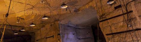 ...Quelques salles sont aménagées à même la roche de la carrière souterraine, les lampes sont accrochées et les circuits de câbles électriques disposés au plafond comme aux murs....