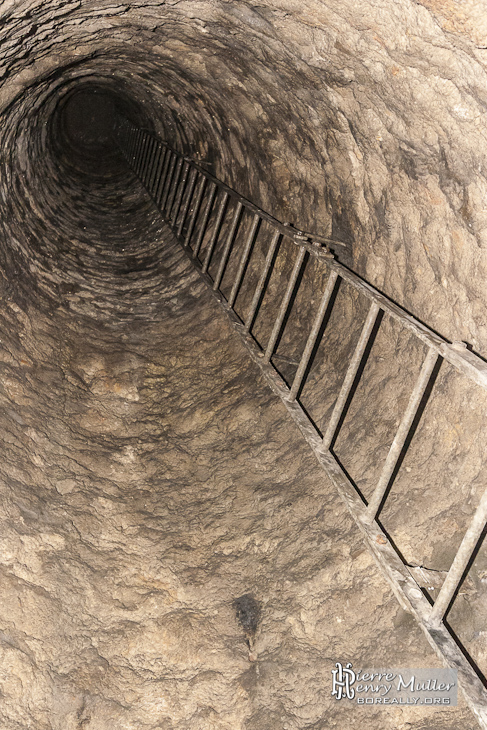 Puits et son échelle dans la salle Anschluss dans les catacombes de Paris