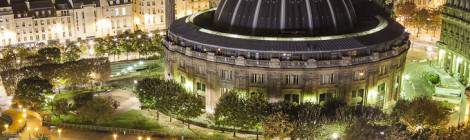 ...Vue depuis les toits sur la Bourse du Commerce de Paris et sa coupole illuminée ainsi que les jardins de la dalle des Halles de nuit....