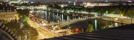 ...Panoramique sur Paris de nuit avec la Seine, le Grand Palais depuis le toit du Musée d’Orsay....
