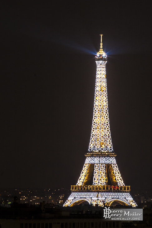 Tour Eiffel illuminée de ses flashs de nuit depuis les toits de Paris
