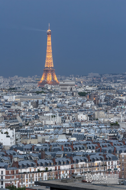 Tour Eiffel et Arc de Triomphe sous un ciel orageux