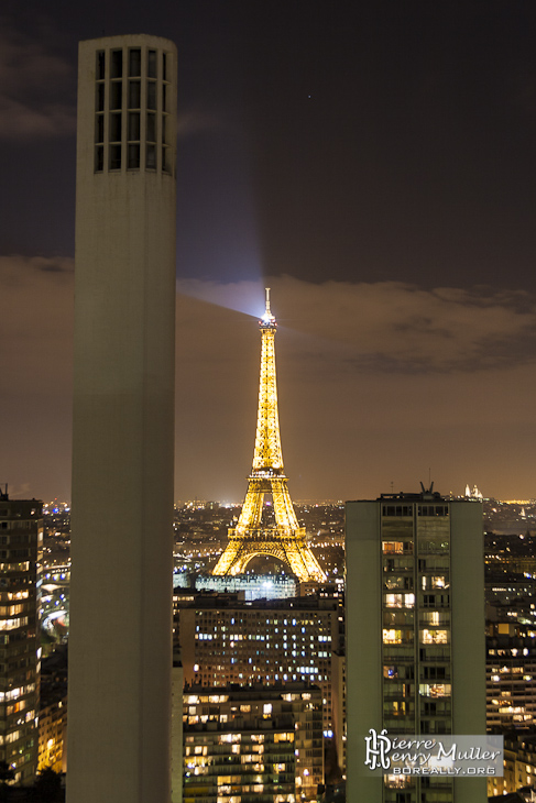 Tour Eiffel et cheminée du chauffage urbain de nuit depuis la tour Paris Côté Seine