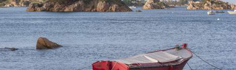 ...Une barque rouge au mouillage entre les rochers à proximité de l’Ile de Bréhat....