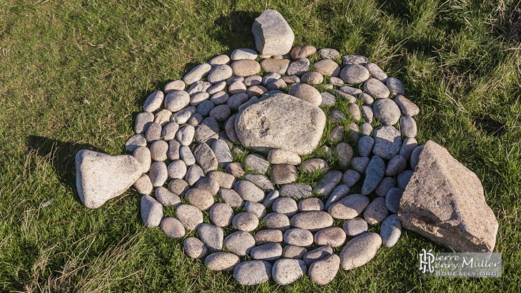 Disposition artistique de galets par des promeneurs sur la côte sauvage