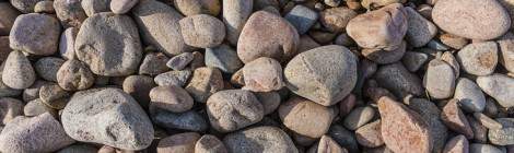 ...Texture de galets de taille moyenne de granite rose sur l’Ile de Bréhat....